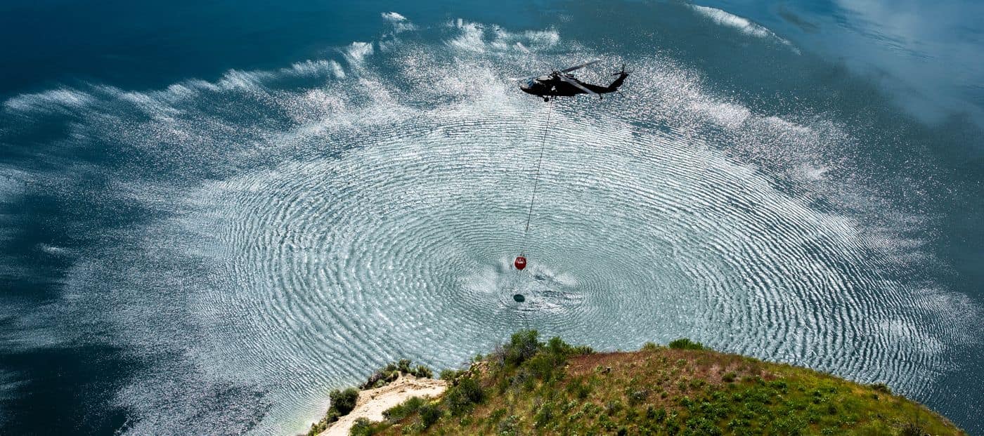 Idaho Army National Guard UH-60 Black Hawk dipping a water bucket during wildfire training, photo by Rusty Rehl
