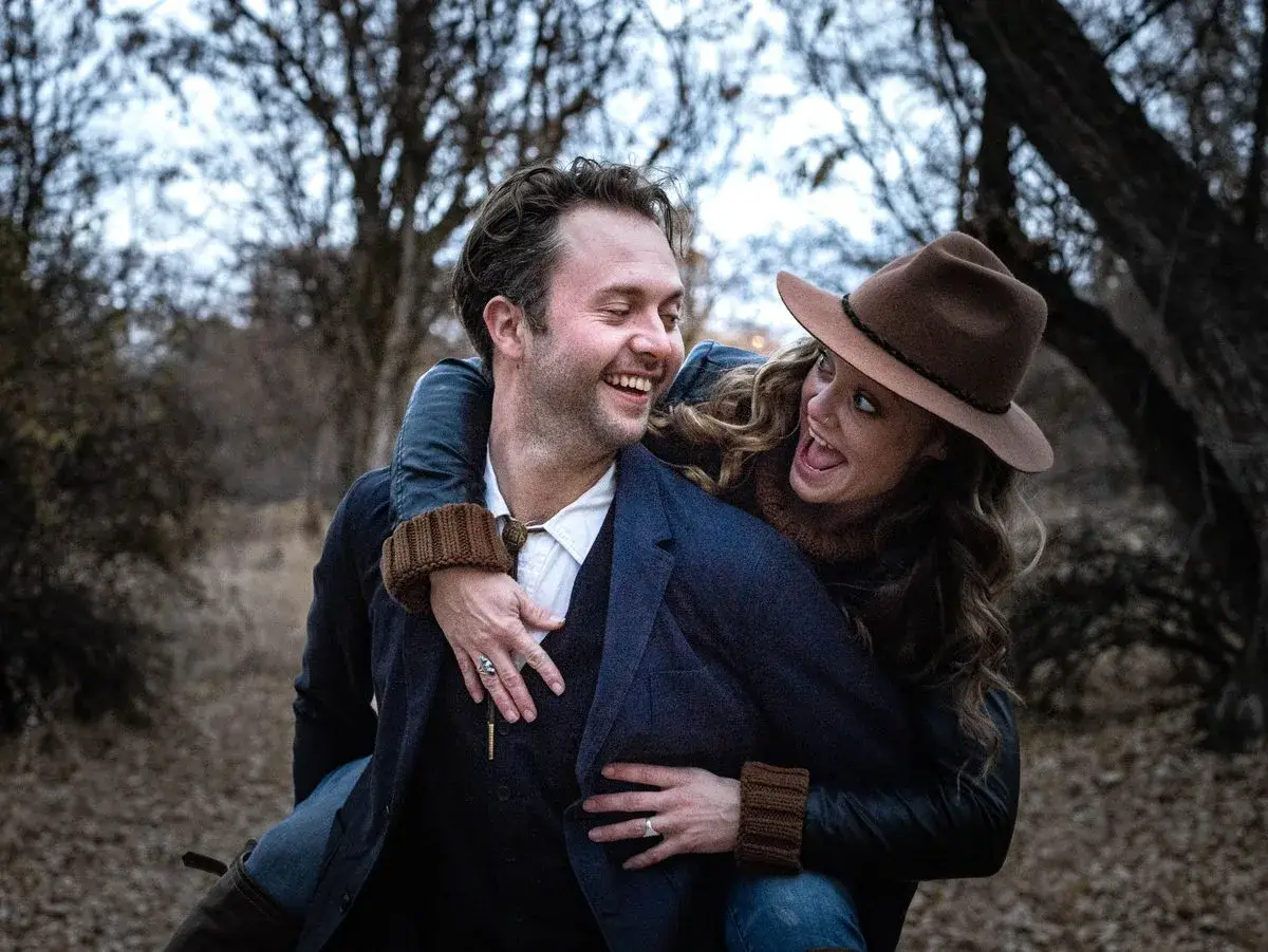 Laughing couple in a piggyback pose, Boise, Idaho engagement photo by Rusty Rehl