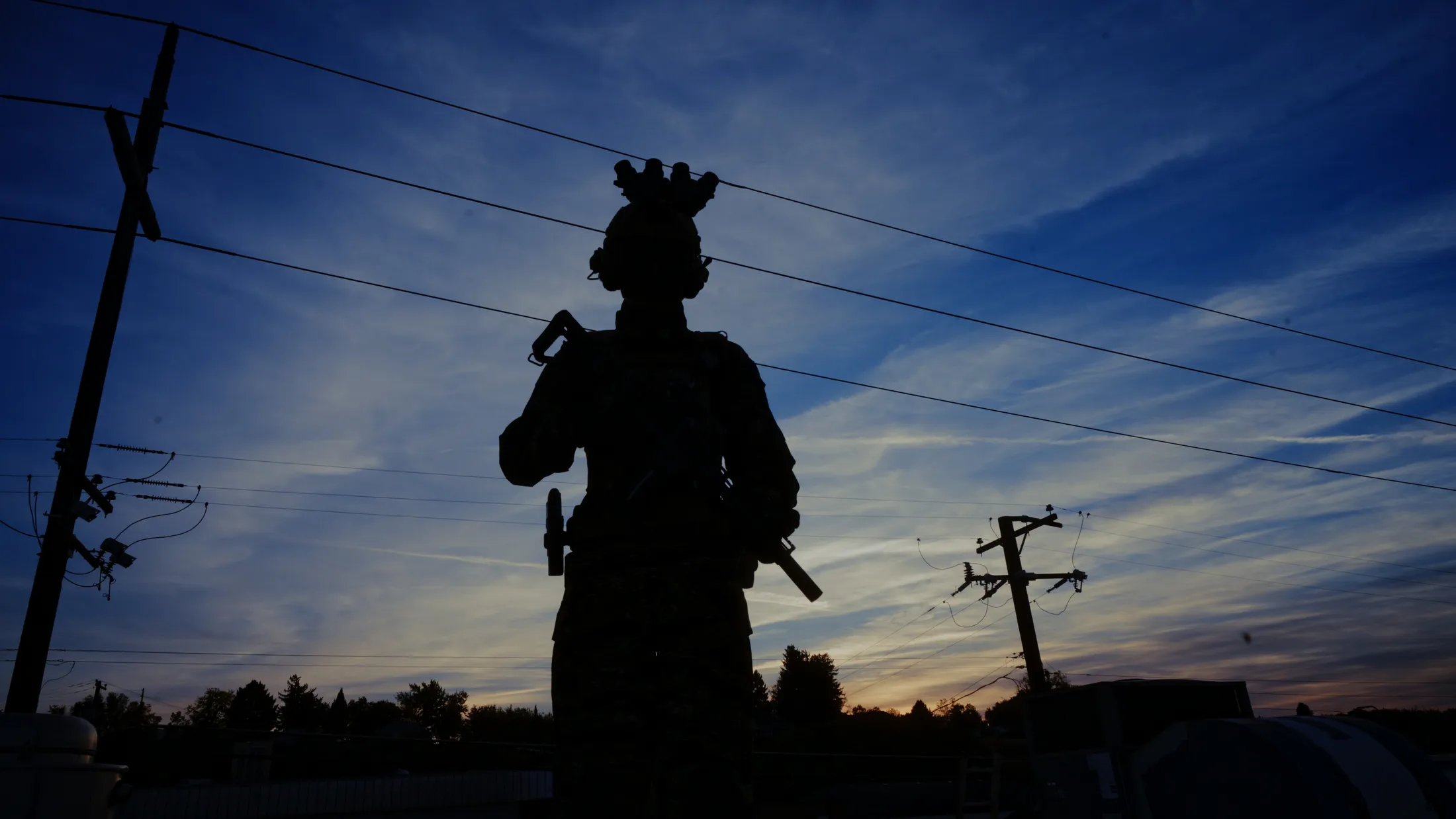 Commando silhouette with night-vision goggles against a dusk sky and power lines, still from Rusty Rehl's Combat Sport Supply ad