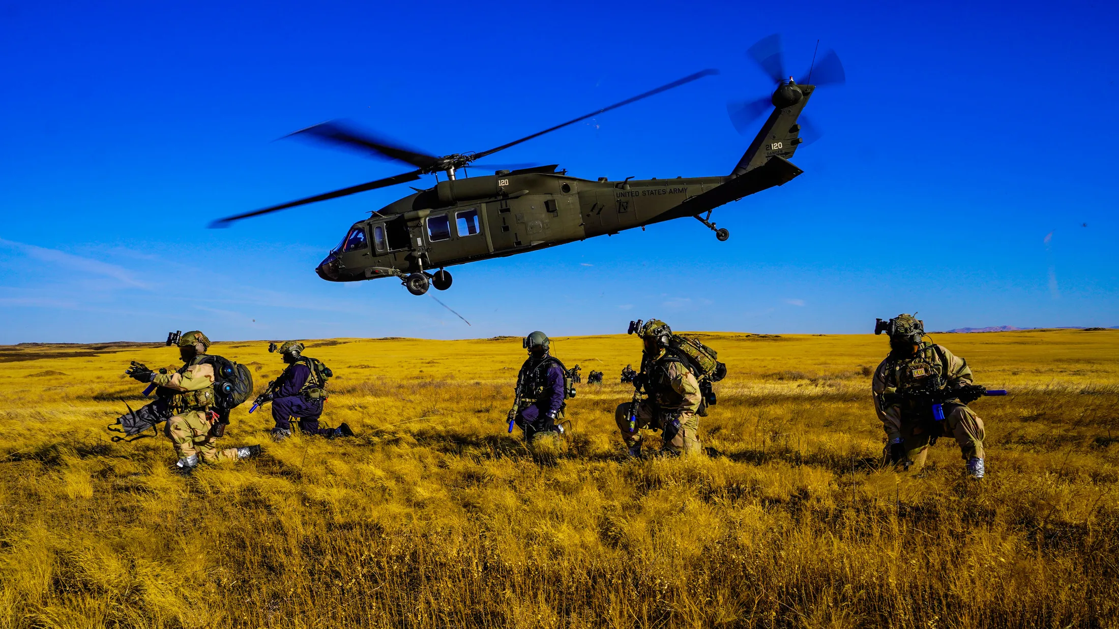 FBI agents in protective gear secure a landing zone as an Idaho Army National Guard UH-60 Black Hawk departs during Exercise Hellgate at Camp Orchard near Boise, Idaho, photo by Rusty Rehl