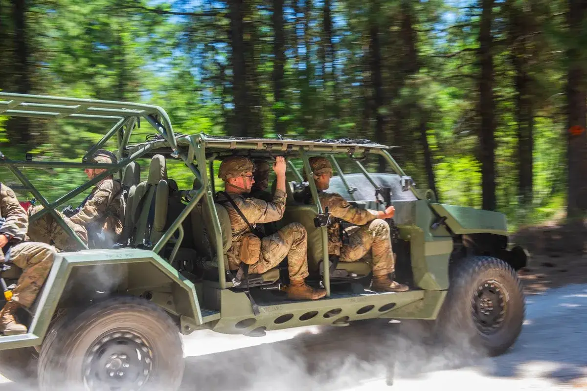 Idaho Army National Guard soldiers ride an Infantry Squad Vehicle through the trees, photo by Rusty Rehl
