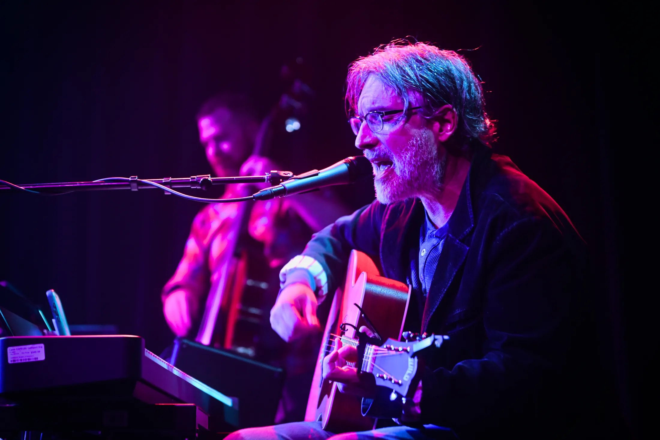 Martin Daniels singing with an acoustic guitar at the keys, Boise, Idaho concert photo by Rusty Rehl