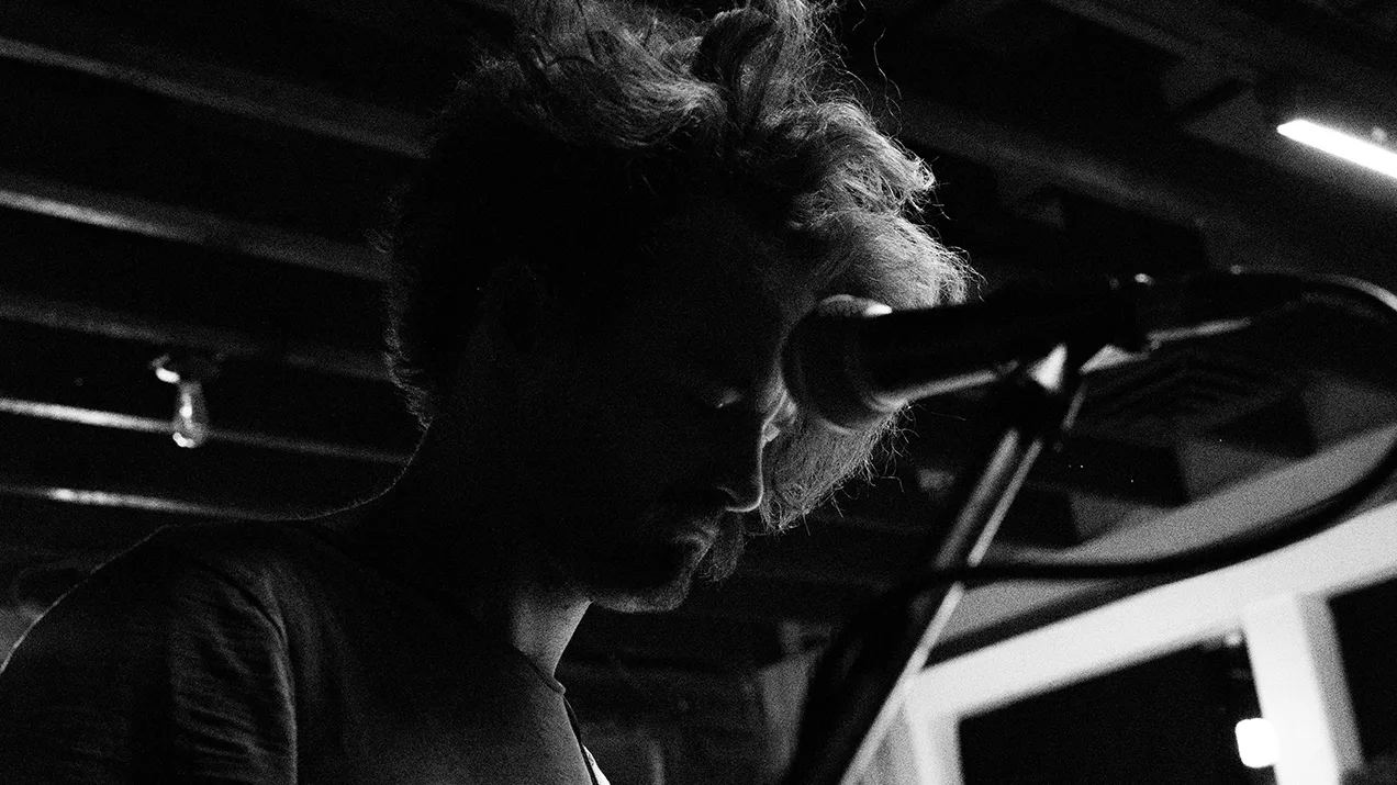 Rooney singer at the microphone in black and white, backlit hair, concert photo by Rusty Rehl
