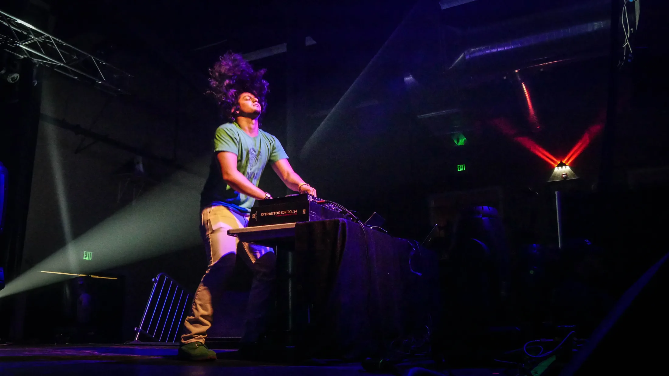 DJ Tej throwing his hair back at the decks under stage lights, live concert photo by Boise, Idaho photographer Rusty Rehl